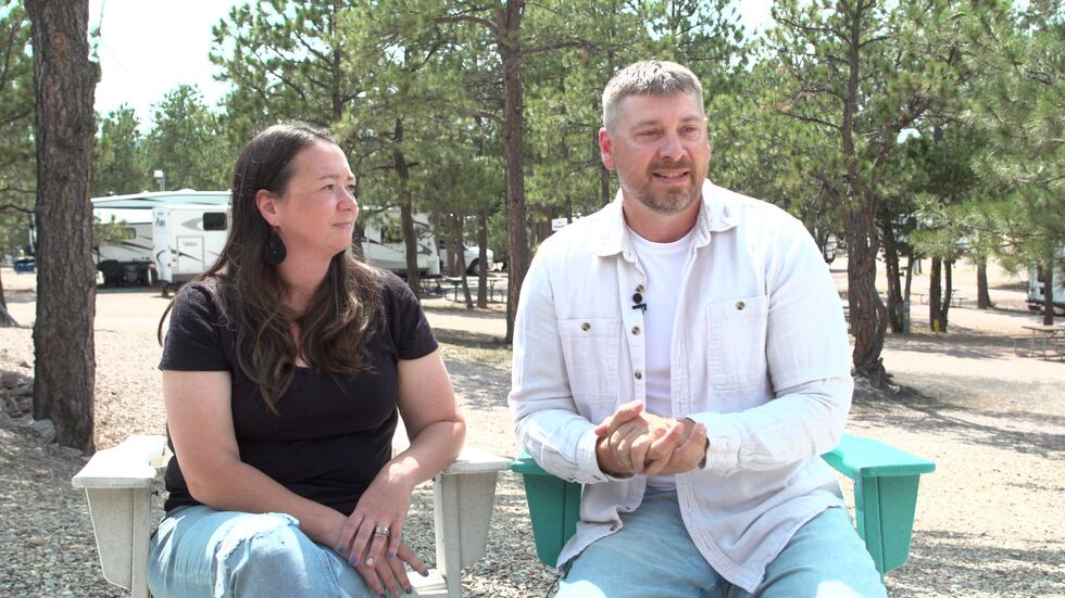 Nicole Weiss (right) and her husband Thad Weiss (left) sit at the firepit at the KOA...