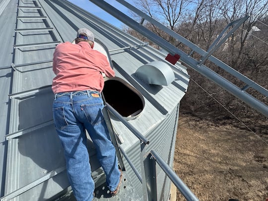 Lyons, S.D., grain farmer Jeff Thompson checks on corn he is storing in bins while awaiting...